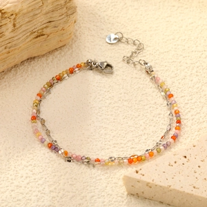 Détail d'un bracelet double couche avec perles multicolores et chaîne en argent élégante