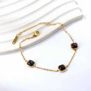 Bracelet chaîne en acier inoxydable doré avec pierres œil-de-chat carrées sur fond blanc