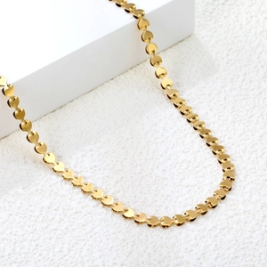 Close-up of golden heart-shaped link necklace with polished finish and elegant metallic drape