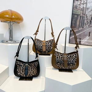 Three retro leopard print shoulder bags in black, camel, and olive green with knot straps