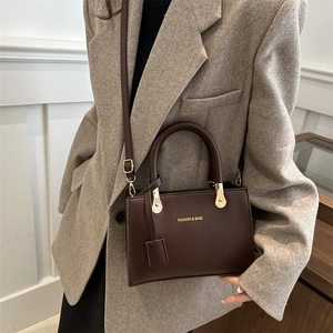 Chic dark brown leather crossbody bag with top handle and gold-tone hardware for women