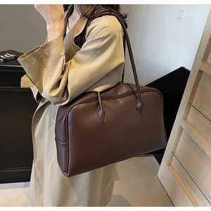 Detail of soft dark brown pebble leather texture and teardrop stitching on large tote bag