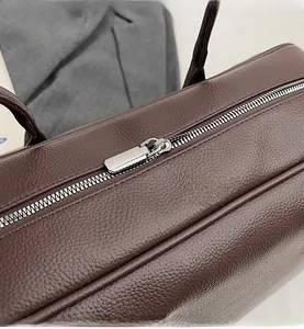 Detail of silver zipper and lychee grain leather texture on brown Boston tote bag