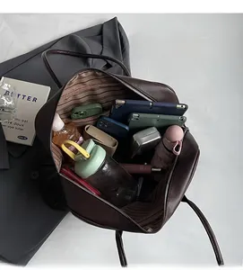 Spacious interior of brown pebbled leather tote bag with striped lining and pockets