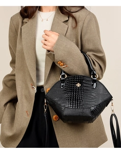Vue détaillée du sac à main noir motif crocodile avec ornement d'abeille dorée en métal