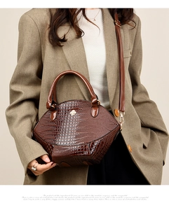 Détail d'un sac à main marron à motif crocodile avec garniture dorée sur mannequin