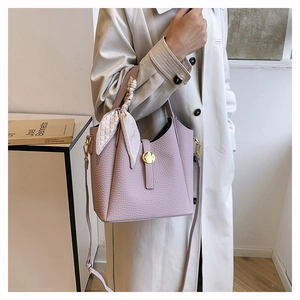 Detail of light purple litchi grain bucket bag with silk scarf handle and gold buckle