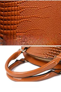 Détail du cuir gaufré crocodile marron brillant et des coutures de la poignée du sac