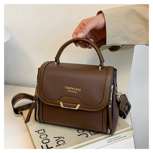 Close-up of brown litchi pattern leather texture and metal bar on the crossbody bag