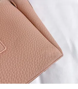Close-up of soft pink lychee grain leather material showing smooth texture and durability