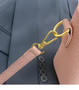 Detail of pink lychee leather strap with gold D-ring and spring hook on bucket bag