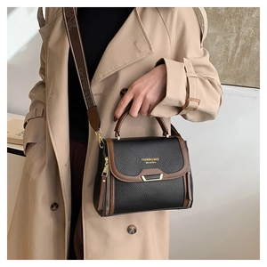 Detail of retro color-block leather handbag with gold hardware and wide logo strap