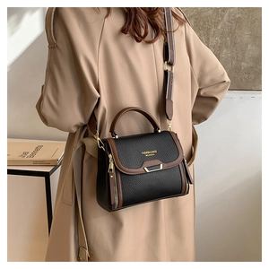 Detail of contrast leather handbag with lychee texture and wide woven shoulder strap