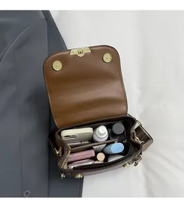 Internal view of brown litchi grain leather bag showing spacious compartments and items