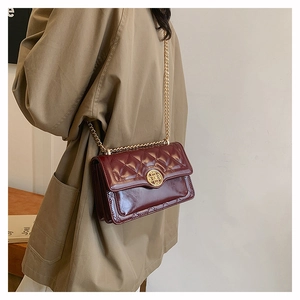 Close-up of burgundy quilted leather bag with vintage gold hardware and chain strap