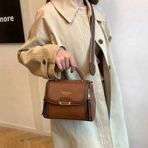 Brown lychee texture handbag with a wide fabric shoulder strap and gold hardware accents