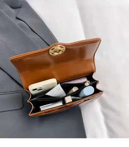 Detail of brown quilted bag interior with multiple compartments and zipper pocket