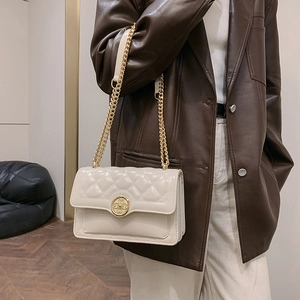 Chic beige quilted crossbody bag with gold floral clasp and metal chain strap