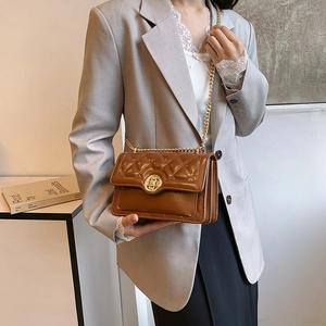 Brown quilted leather crossbody bag with vintage gold chain strap on a modern model