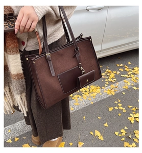 Détail du grand sac cabas en daim marron avec porte-monnaie assorti dans un décor d'automne