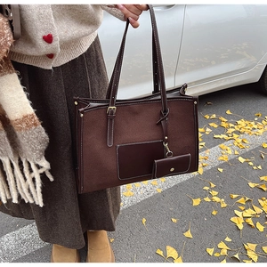 Détail du grand sac cabas marron avec coutures contrastées et petit porte-monnaie