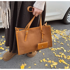 Vue détaillée du grand sac cabas marron avec rivets et mini pochette zippée assortie