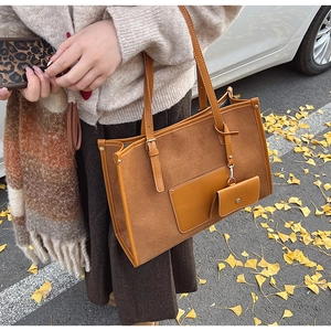 Détail du grand sac cabas en daim marron avec mini pochette assortie et doubles anses