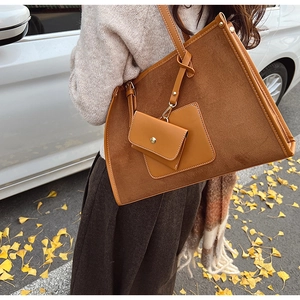 Détail du sac cabas en daim marron avec mini pochette assortie et surpiqûres décoratives