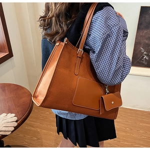 Détail d'un grand cabas en daim marron avec porte-monnaie amovible et une poche plate