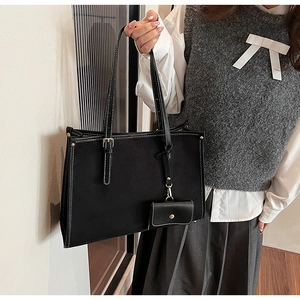 Détail du sac cabas noir avec surpiqûres blanches et son mini porte-monnaie assorti