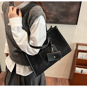 Détail du grand sac cabas noir avec surpiqûres blanches et mini porte-monnaie sur le mannequin