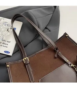 Detail of adjustable leather strap and suede patchwork on brown minimalist tote bag