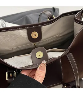 Detailed view of tote bag featuring magnetic buckle and herringbone fabric lining