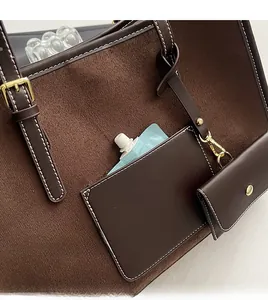 Detail of brown tote bag showing the front pocket, suede texture and small hanging pouch