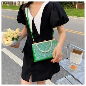 Detail of green sequin evening bag with pearls and gold metal frame closure