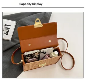Interior view showing the storage capacity for smartphones and makeup in a brown crossbody bag
