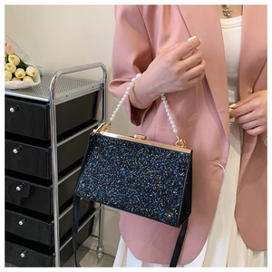 Detailed close-up of black sequin evening clutch bag with elegant pearl handle beads