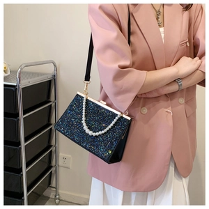 Detail of luxury sequined evening bag with pearl handle and metal clasp closure