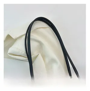 Détail des bandoulières confortables en cuir noir sur un sac cabas en laine à carreaux