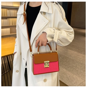 Detail of color-block box bag featuring brown and magenta textures with gold twist lock