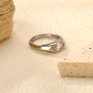 Anello minimalista in acciaio inossidabile con zircone marquise su sfondo di pietra