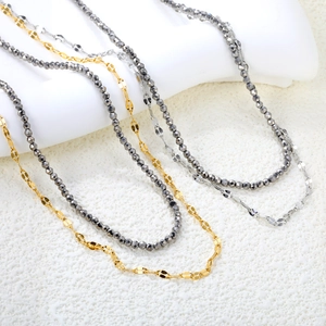 Layered necklace with gold and silver flat chains and faceted dark grey bead strand
