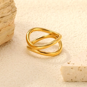 Macro detail of intertwined gold wave rings with polished finish on natural stone