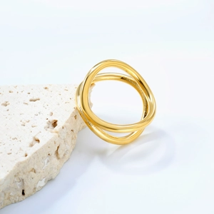 Polished gold double band interlocking ring displayed on light textured stone