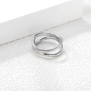 Macro detail of silver geometric double ring with polished finish on white pedestal