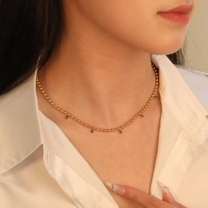 Vintage emerald teardrop necklace with 18K gold-plated beads on a female model