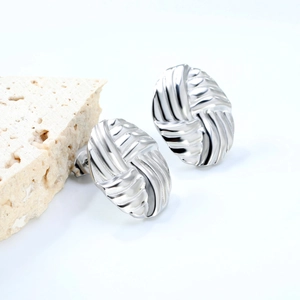 Detail shot of silver oval braided earrings with a textured surface on a stone