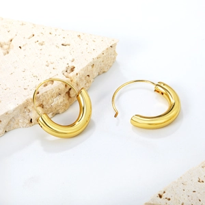Gros plan de boucles d'oreilles créoles dorées épaisses avec finition miroir