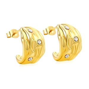 Irregular C-shaped gold metal earrings with lava texture and zircon stones on white background