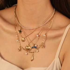 Gold layered ocean necklace with shell, starfish and blue fish tail charms